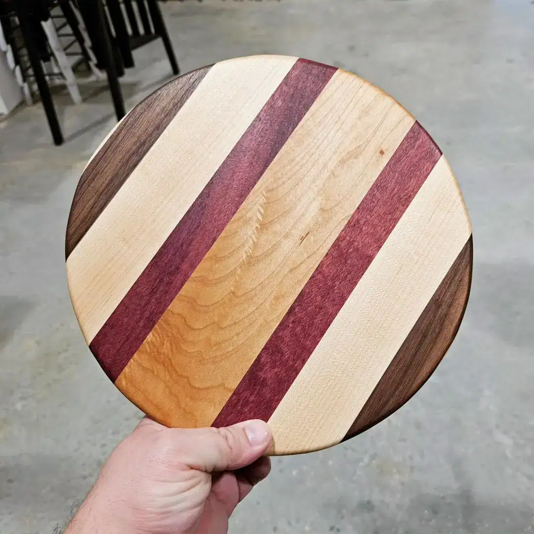 a circular cutting board with walnut maple and purpleheart wood pieces a circular cutting board with walnut maple and purpleheart wood pieces
