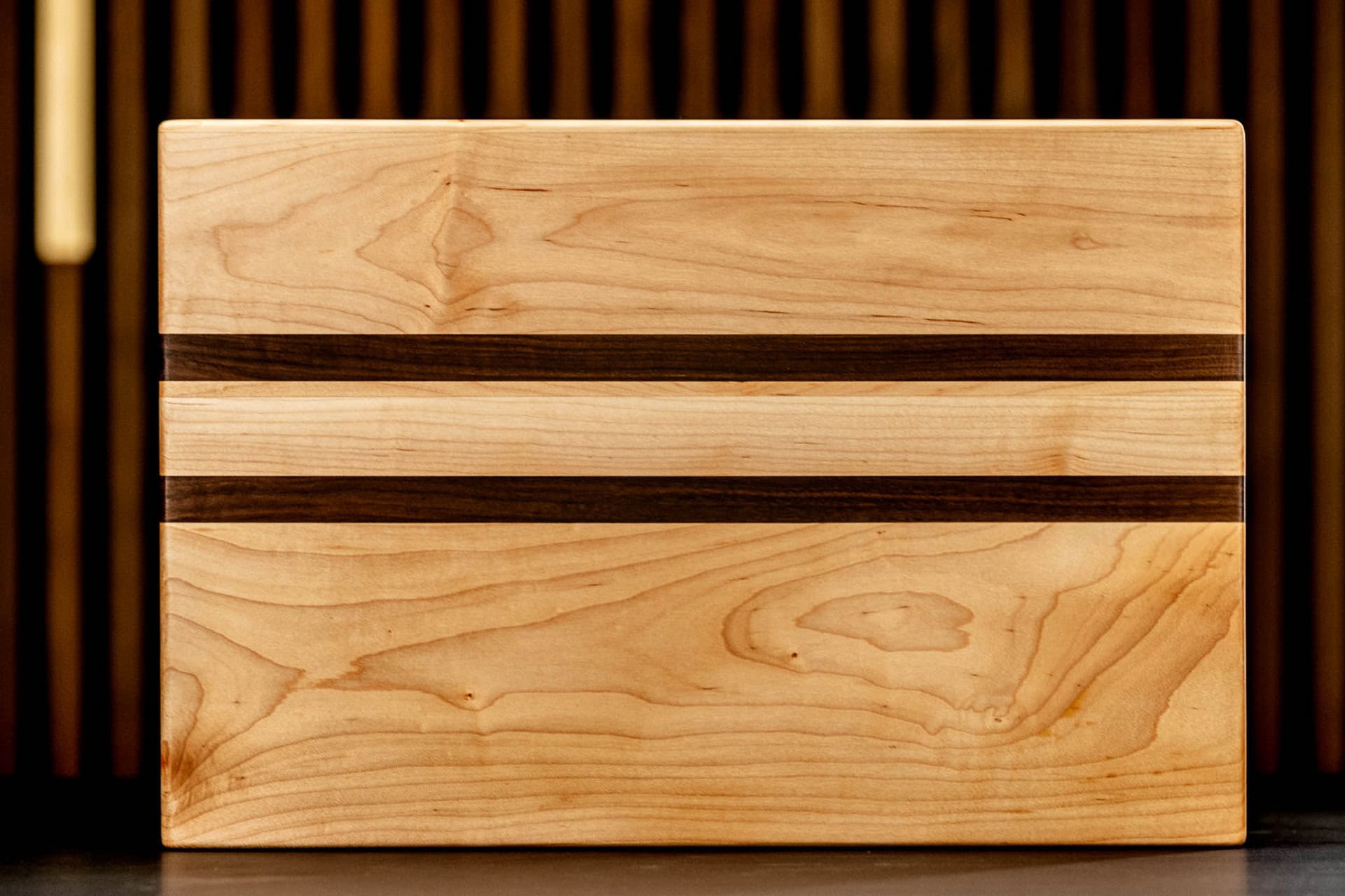Elegant wooden storage box with dark accent stripes, showcasing craftsmanship and quality woodworking. Perfect for home organization and decor.